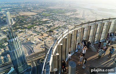 Tourists meet the sunrise on the observation deck of the Burj Khalifa tower. © TOXAWWW | DREAMSTIME