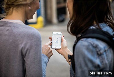 Two tourists in New York look at their phone and wait for a Lyft driver to arrive